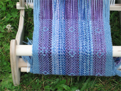 Blue scarf being woven on a rigid heddle loom