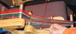 Cookie Mesmer weaving on an inkle loom